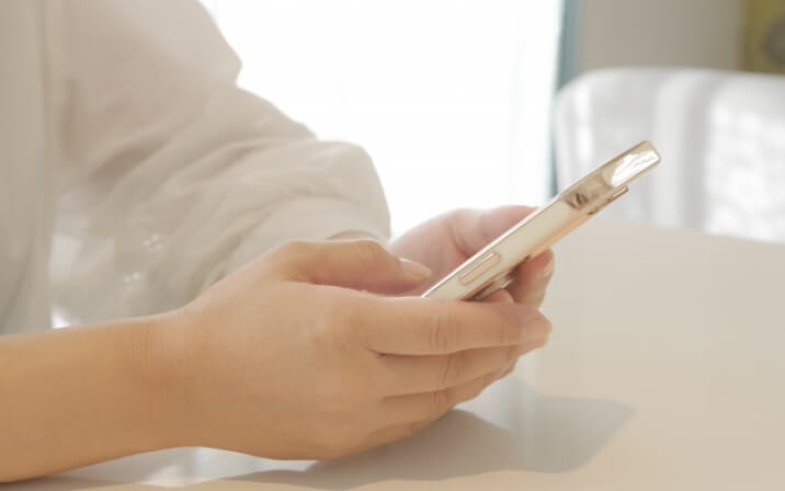 スマートフォンを操作する女性の手